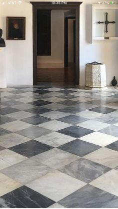 a black and white checkered tile floor in a room with paintings on the wall