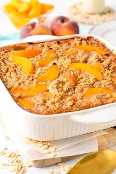 a casserole dish with peaches and oatmeal on the side