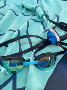 two swimming goggles laying on top of a blue blanket