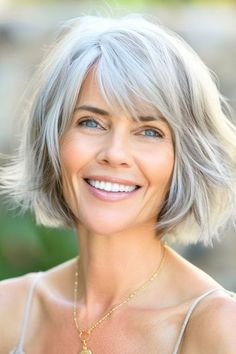 Voluminous Bob with Bangs Hairstyle on smiling woman in her 40s with silver hair. Medium Length Grey Wavy Hair Styles Over 50, Shoulder Length Curly Grey Hair Over 50, Chin Length Grey Hair With Bangs, Grey Bob Hairstyles Over 50 With Fringe, Short Grey Shag Wigs, Natural Wavy Hair, Voluminous Curls, Shag Hairstyles