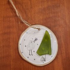 a green piece of glass sitting on top of a wooden table next to a string