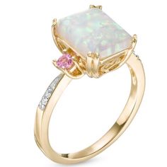 Fashioned In 10k Gold, This Three Stone Ring Features A 10.0 X 8.0mm Emerald-Cut Lab-Created Opal Center Stone Flanked On Either Side By Two Lab-Created Pink Sapphires With Diamond Accents Lining The Ring's Shank. Three Stone Ring, 5 Rings, Ring Color, Three Stone Rings, Three Stone, 10k Gold, Stone Ring, Pink Sapphire, Womens Jewelry Rings