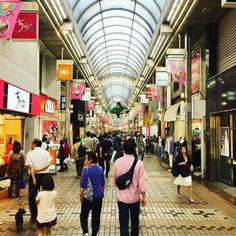 many people are walking through an indoor shopping mall