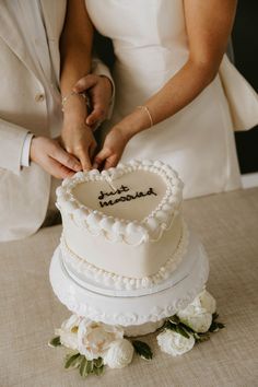 a bride and groom are cutting their wedding cake with the word love spelled on it