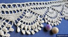 crocheted white lace with beads on blue background