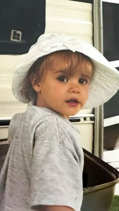 a small child wearing a white hat