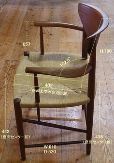 a wooden chair sitting on top of a hard wood floor next to a table with measurements