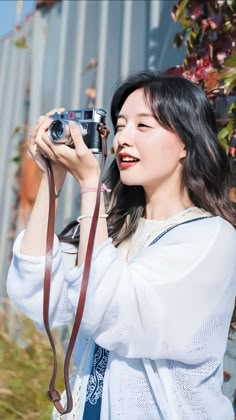 a woman holding a camera up to her face