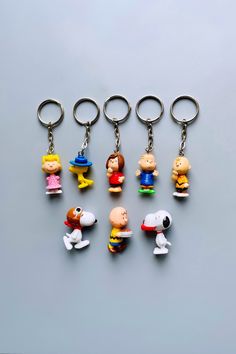 six different key chains with cartoon characters on them, all in different colors and sizes