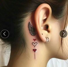 a woman's behind the ear tattoo with hearts and wings