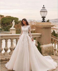 a woman in a wedding dress standing on a balcony