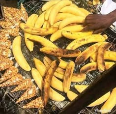 bunches of bananas and ginger on a grill with someone reaching for them to grab one