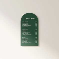 a green coffee menu hanging on the wall