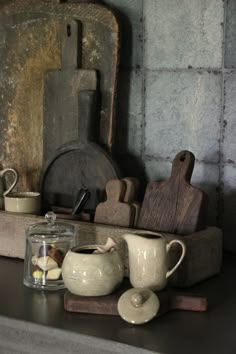 an assortment of kitchen utensils on a shelf in front of a wall mirror