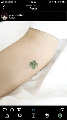 a small four leaf clover tattoo on the left side of the foot, with an arrow in the middle