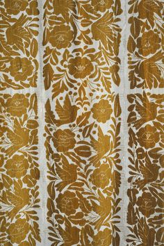 an intricately designed wallpaper with gold and white designs on the outside, including leaves