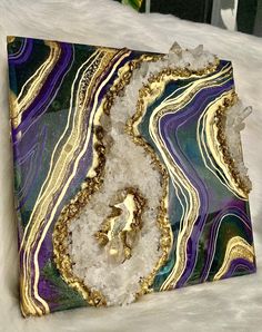 an abstract painting with gold and purple colors