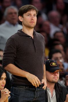 a man standing next to a woman at a basketball game