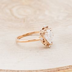 a diamond ring sitting on top of a wooden table