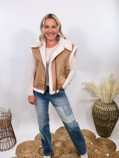 Camel Tan Suede Vest with Sherpa Trim Upgrade your winter wardrobe with our Camel Tan Suede Vest with Sherpa Trim. This chic vest is perfect for a stylish snow day outfit, offering a luxurious look and feel that will make you stand out. The soft suede material in a rich camel tan color is complemented by plush fur trim at the edges, giving it a high-end, sophisticated vibe. With a zipper front and side pockets, this vest combines practicality with elegance. The relaxed fit ensures comfort, makin Chic Brown Winter Vest, Fall Sleeveless Outerwear With Faux Fur Trim, Sleeveless Outerwear With Faux Fur Trim For Fall, Sleeveless Outerwear With Faux Fur Lining For Fall, Sleeveless Fall Outerwear With Faux Fur Lining, Cozy Winter Vest For Cold Weather, Brown Winter Vest Outerwear, Winter Beige Sleeveless Outerwear, Trendy Brown Winter Vest