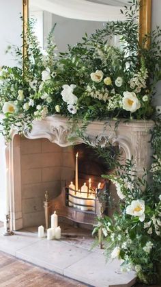 a fireplace with flowers and candles on it