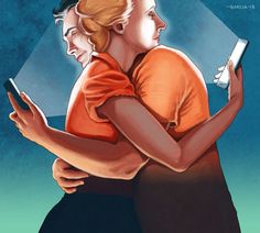 two people hugging each other while looking at their cell phones