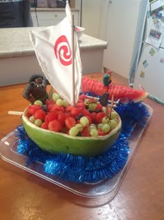 a boat made out of watermelon, grapes and strawberries on a table