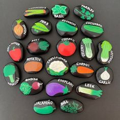 a collection of painted rocks with vegetables on them