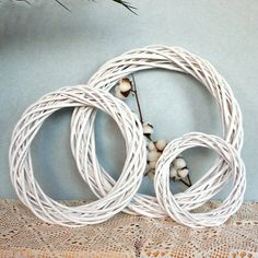 three white cords are sitting on a lace doily next to a branch with flowers