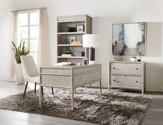 a living room filled with furniture and a large painting on the wall above a desk