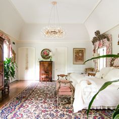 a bedroom with a large rug and chandelier hanging from it's ceiling