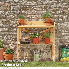 a wooden shelf filled with potted plants next to a stone wall