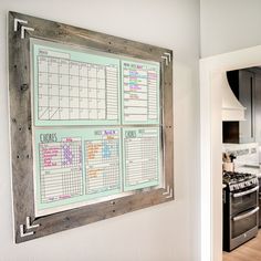 a kitchen wall with a calendar hanging on it's side next to a dining room table