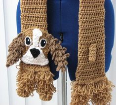 a crocheted dog scarf hanging on a mannequin