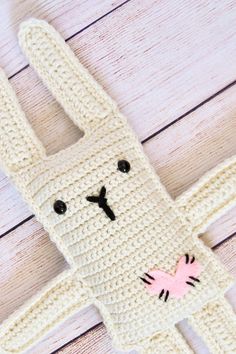 a crocheted stuffed animal is laying on the floor next to a wooden table