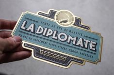 a person holding up a sticker with the word la diplomatee on it