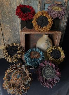 an arrangement of sunflowers sitting on top of a wooden shelf