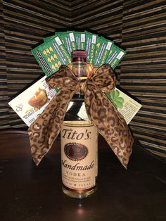 a bottle filled with lots of liquor sitting on top of a table next to some cards