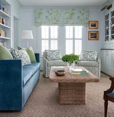 a living room with two couches and a coffee table in front of a window