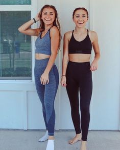 two young women standing next to each other in front of a white wall wearing sports bra tops and leggings