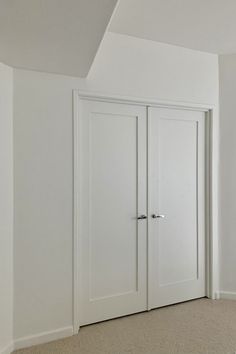 an empty room with two white doors and no one in the room looking at it