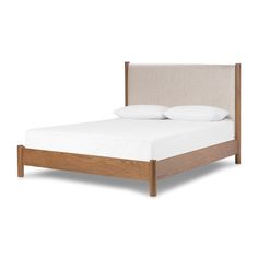 a bed with two pillows on top of it and a headboard made out of wood