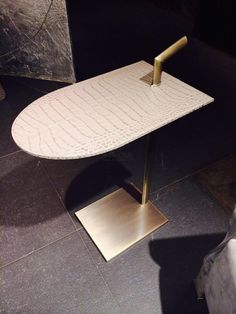 an ironing board on display in a room with black walls and tile flooring