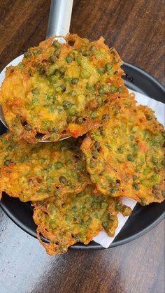 three fritters sitting on top of a black plate