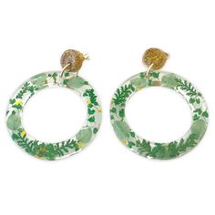 the hoop earrings are decorated with green leaves and gold glittered birds on top of them