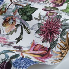 a close up view of a flowered fabric with leaves and flowers on the side