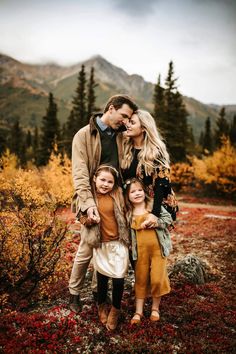 a family posing for a photo in the mountains