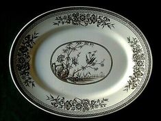 an antique black and white plate with flowers on it