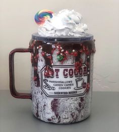 a coffee mug with marshmallows and candy cane in it