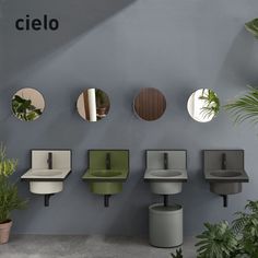 several circular mirrors mounted on the wall next to plant pots and stools with plants in them